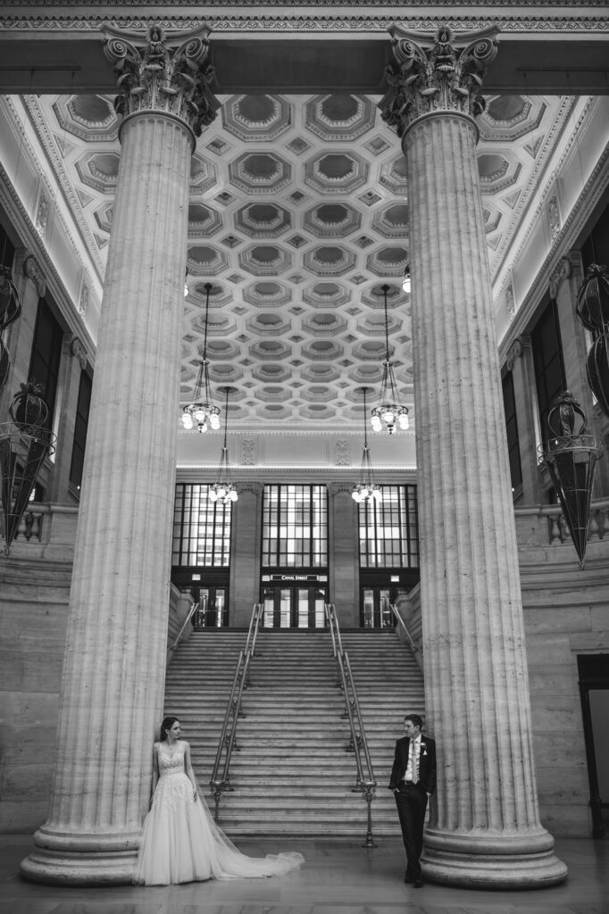 Bride and groom lean again pillars at Chicago Union Station