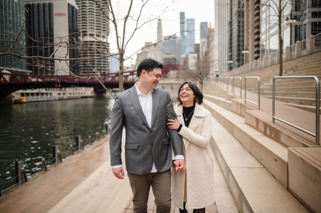 A couple hold hands while walking down the Chicago Riverwalk in the spring.