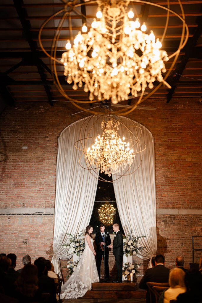 Bride an groom get married at night at the Bridgeport Arts Center in Chicago, IL.