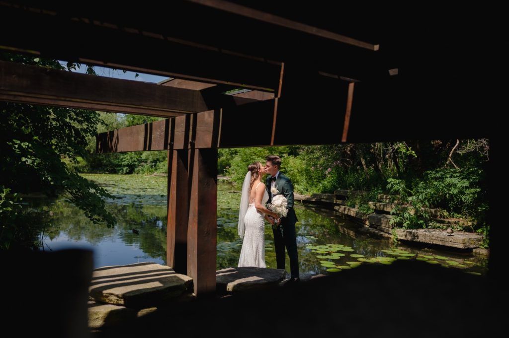 Bride and groom kiss at the Alfred Caldwell Lily Pool