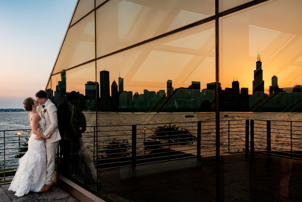 Chicago skyline is reflected in the window at the Adler Planetarium in Chicago during sunset.