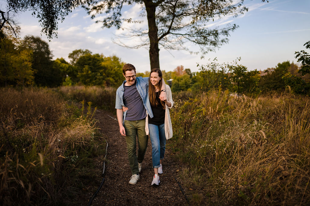 A couple wrap their arms around each other  while walking on the nature path at Horner Park. 