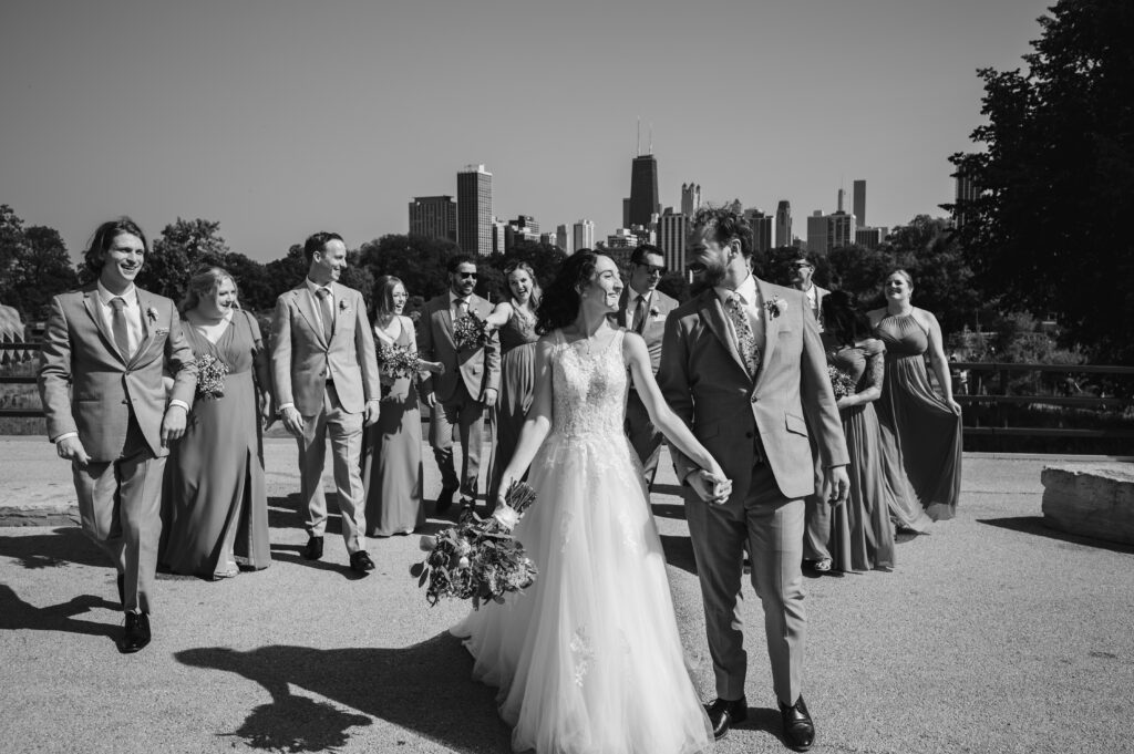 A couple walk with their wedding party in Lincoln Park. 