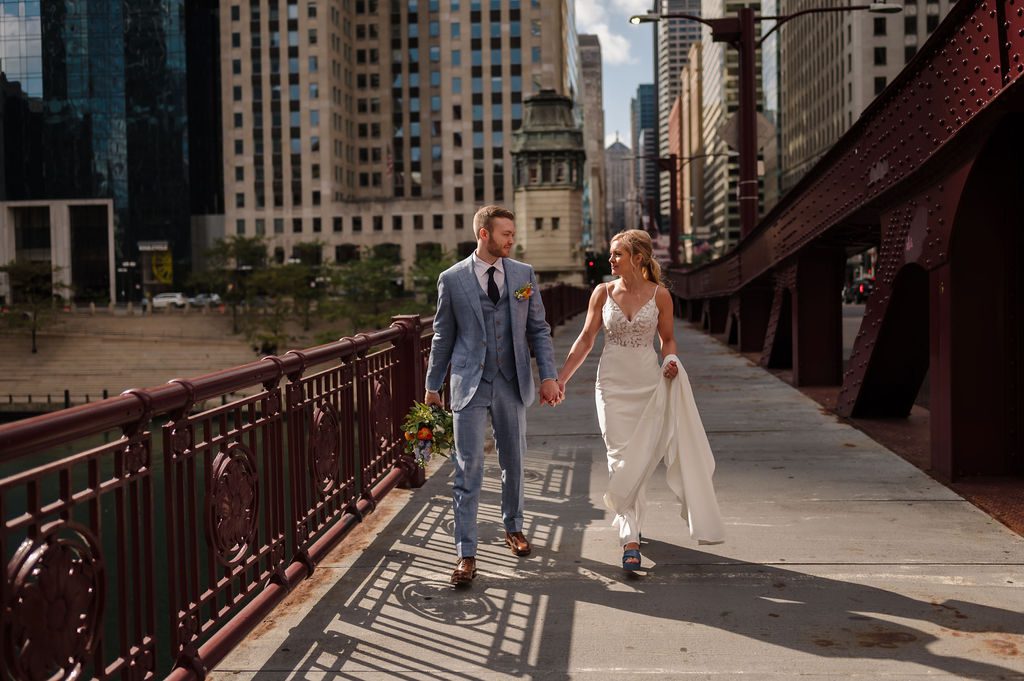 Bride and groom walk on LaSalle Bride in Chicago, IL
