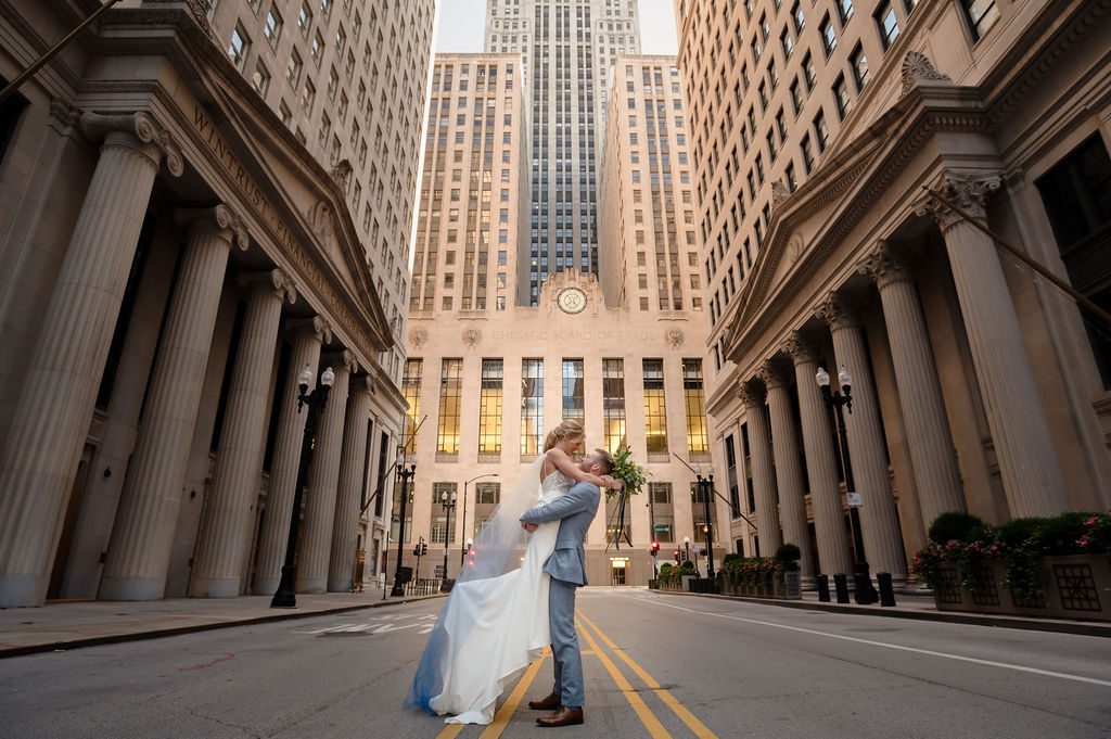 Grooms lifts up bride in front of the Chicago Board of Trade.