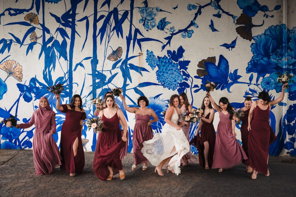 Bridesmaids dance in front of mural at Ping Tom Memorial Park.