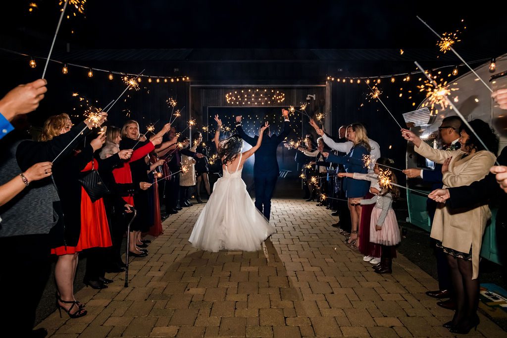 A couple runs past wedding guests during sparkler exit at Warehouse 109 in Plainfield, IL