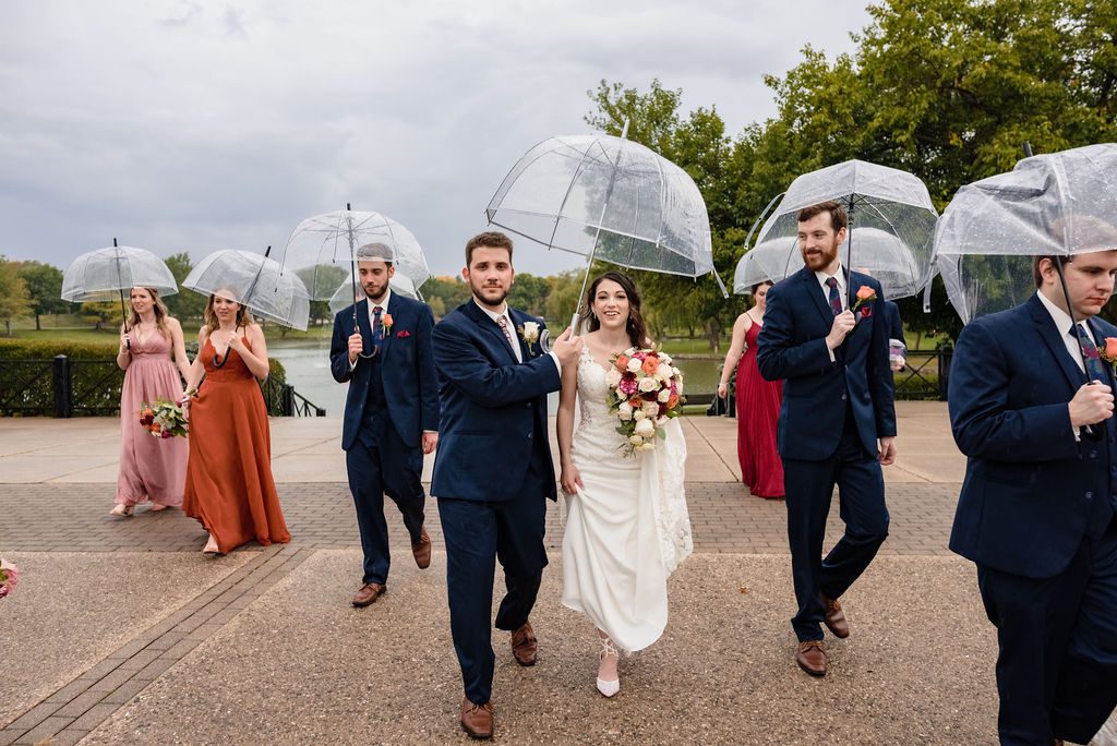 Bride and groom hold umbrellas at the Sculpture Garden in Schaumburg, IL