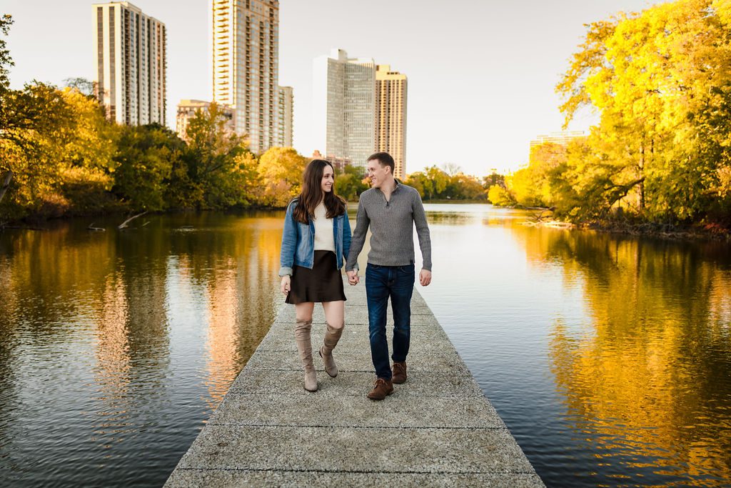 A couple walks on a bride over water in Lincoln Park.