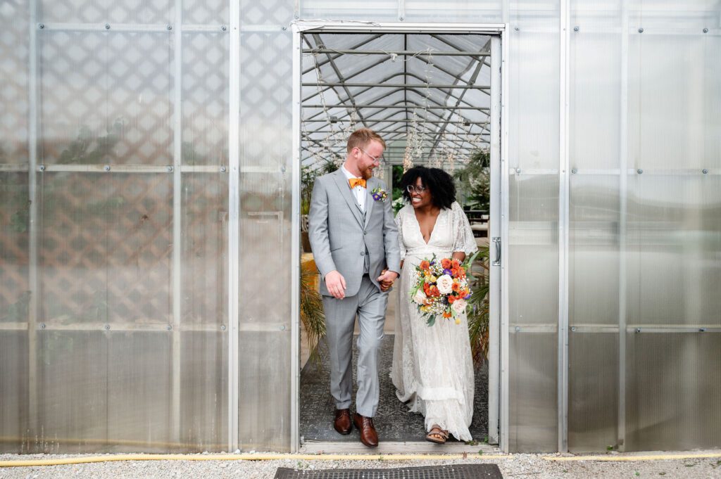 Bride and groom hold hand walking at Heritage Prairie Farm 
