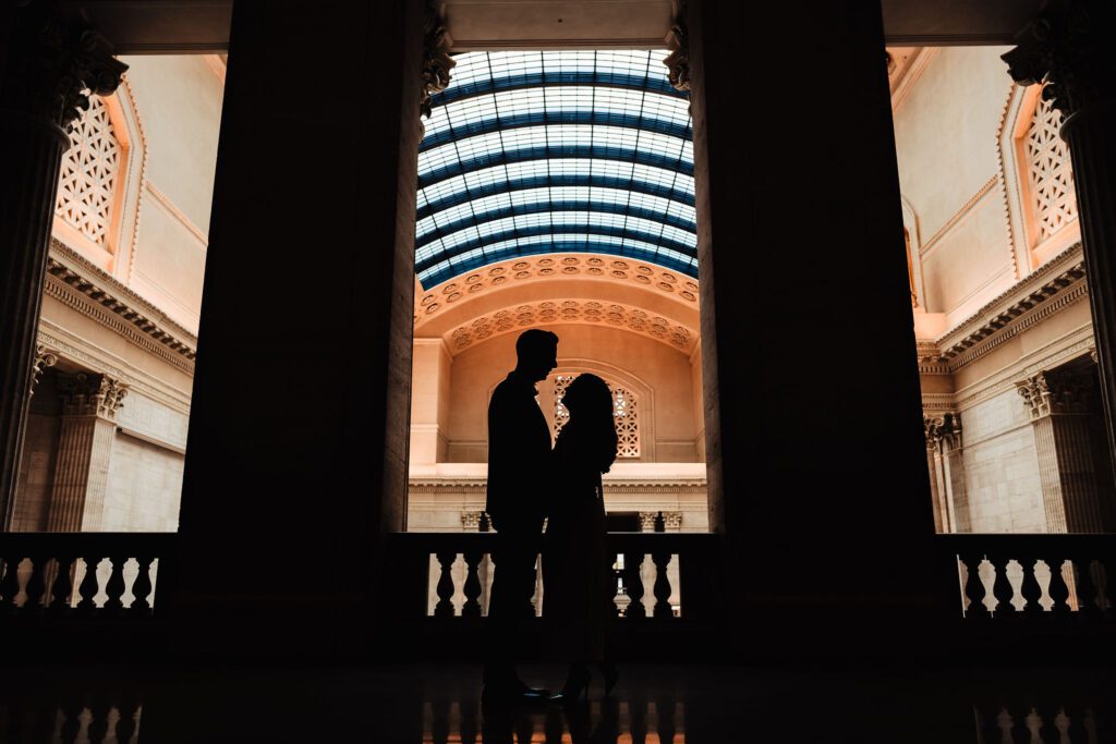 A couple embraces and is silhouetted from the light at the Chicago Union Station.