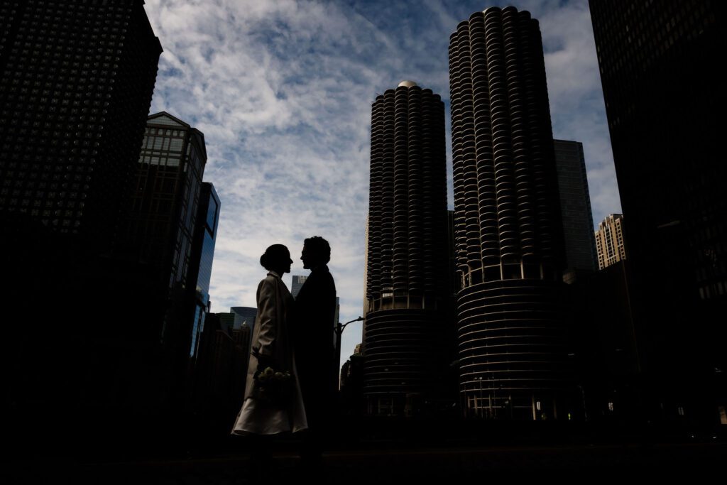 A couple silhouetted in front of marine tower in Chicago, IL