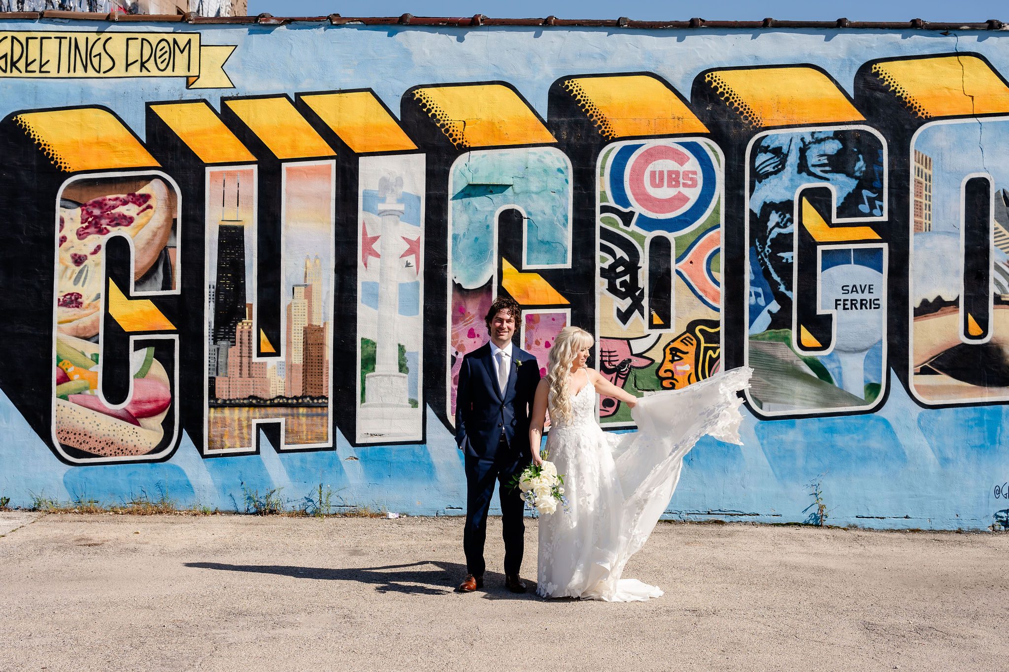 Bride and groom in front of the Greetings from Chicago Mural.