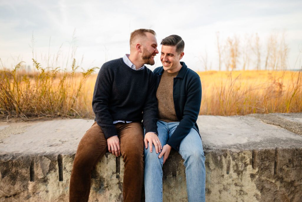 Two men sit close to each other at Montrose Beach in Chicago