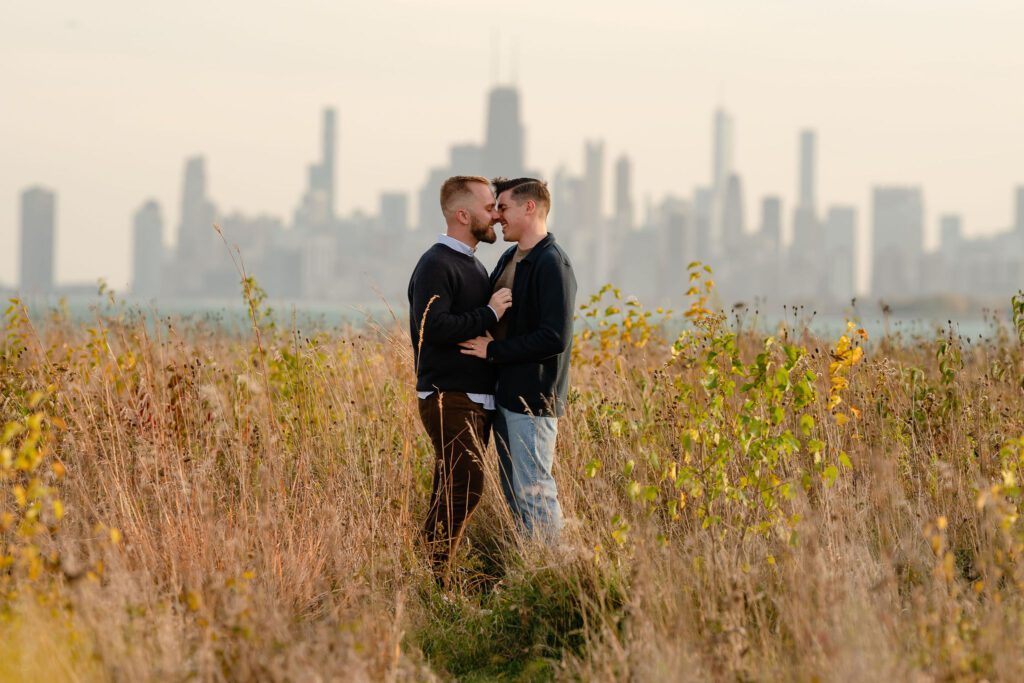 LGBTQ couple get close at the Montrose Bird Sanctuary in front of the Chicago skyline.