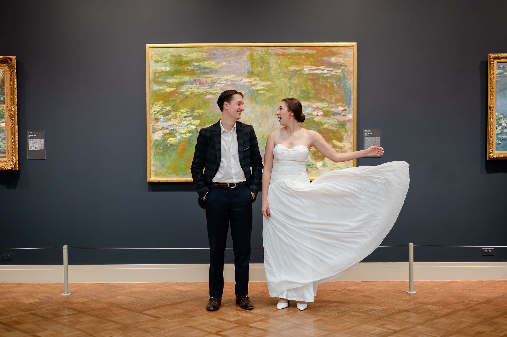 Bride and groom stand in front of a Monet painting