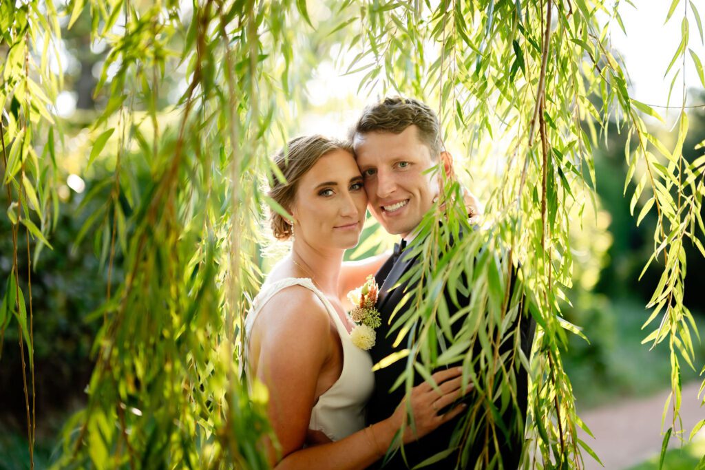 Bride and groom behind a Willow tree 