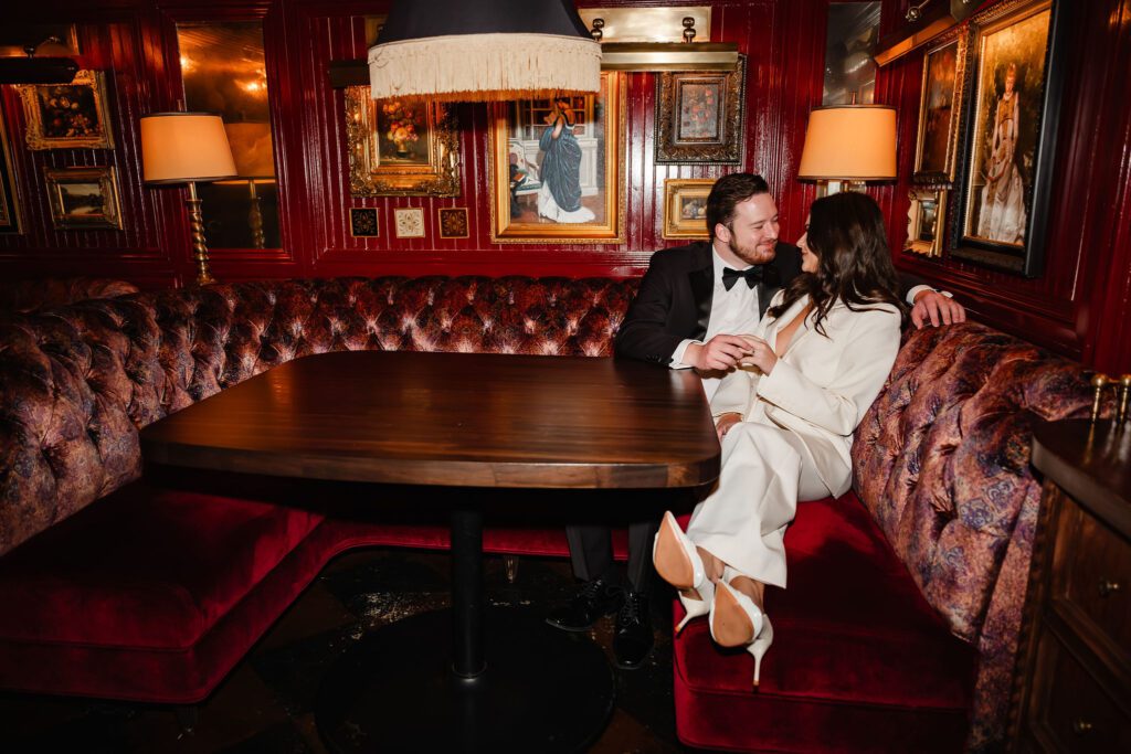 Man and women snuggle in a moody booth at Gilt Bar in Chicago.