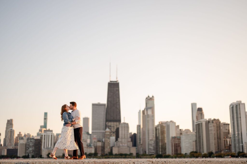 A couple kiss in front of the Chicago skyline at North Avenue Beach.