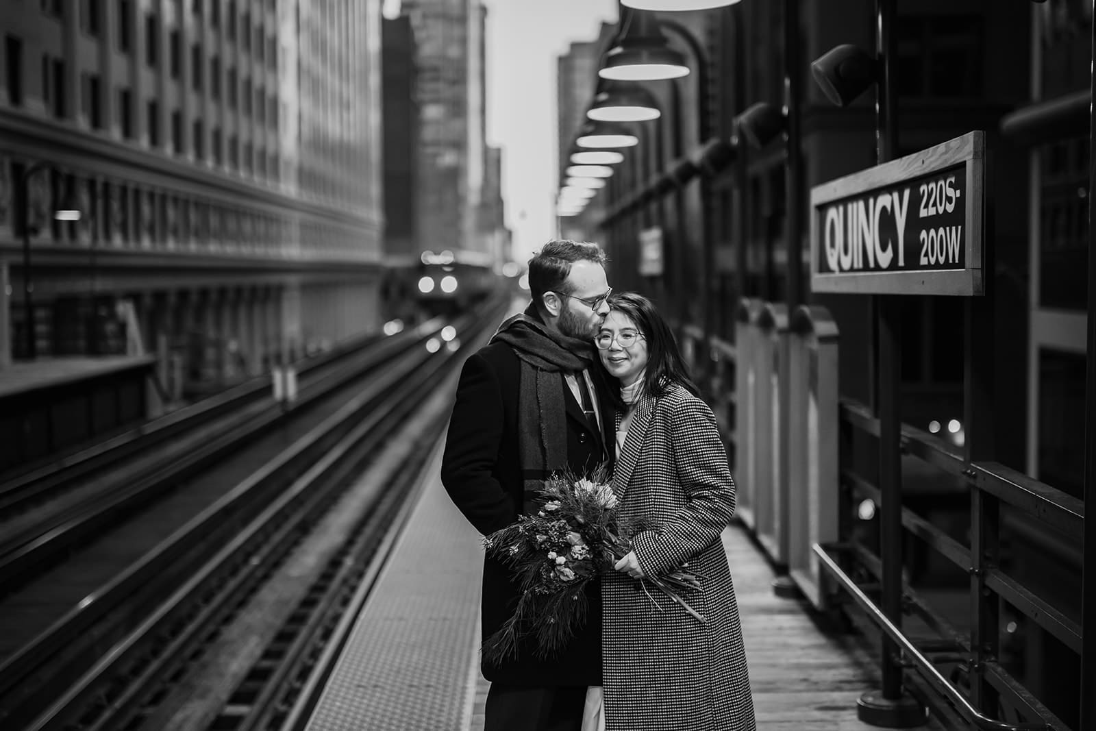 A couple kiss while waiting for train on the Quincy Brown Line in Chicago.