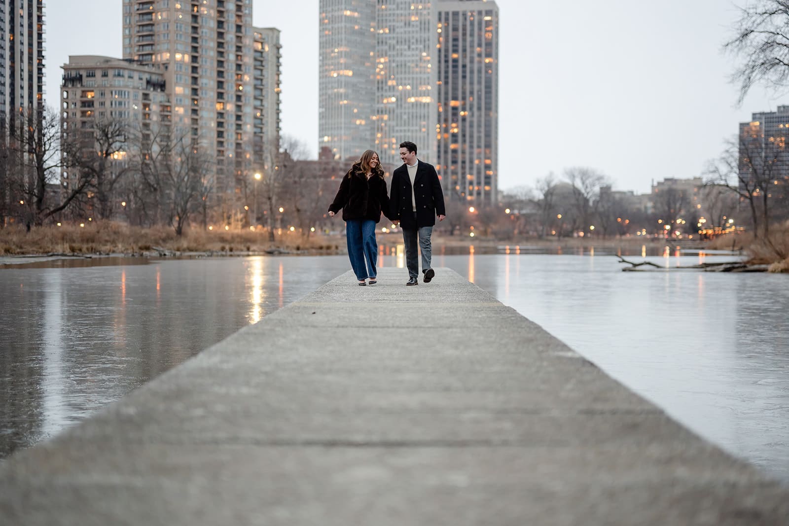 A couple walk on a bridge after getting engaged.
