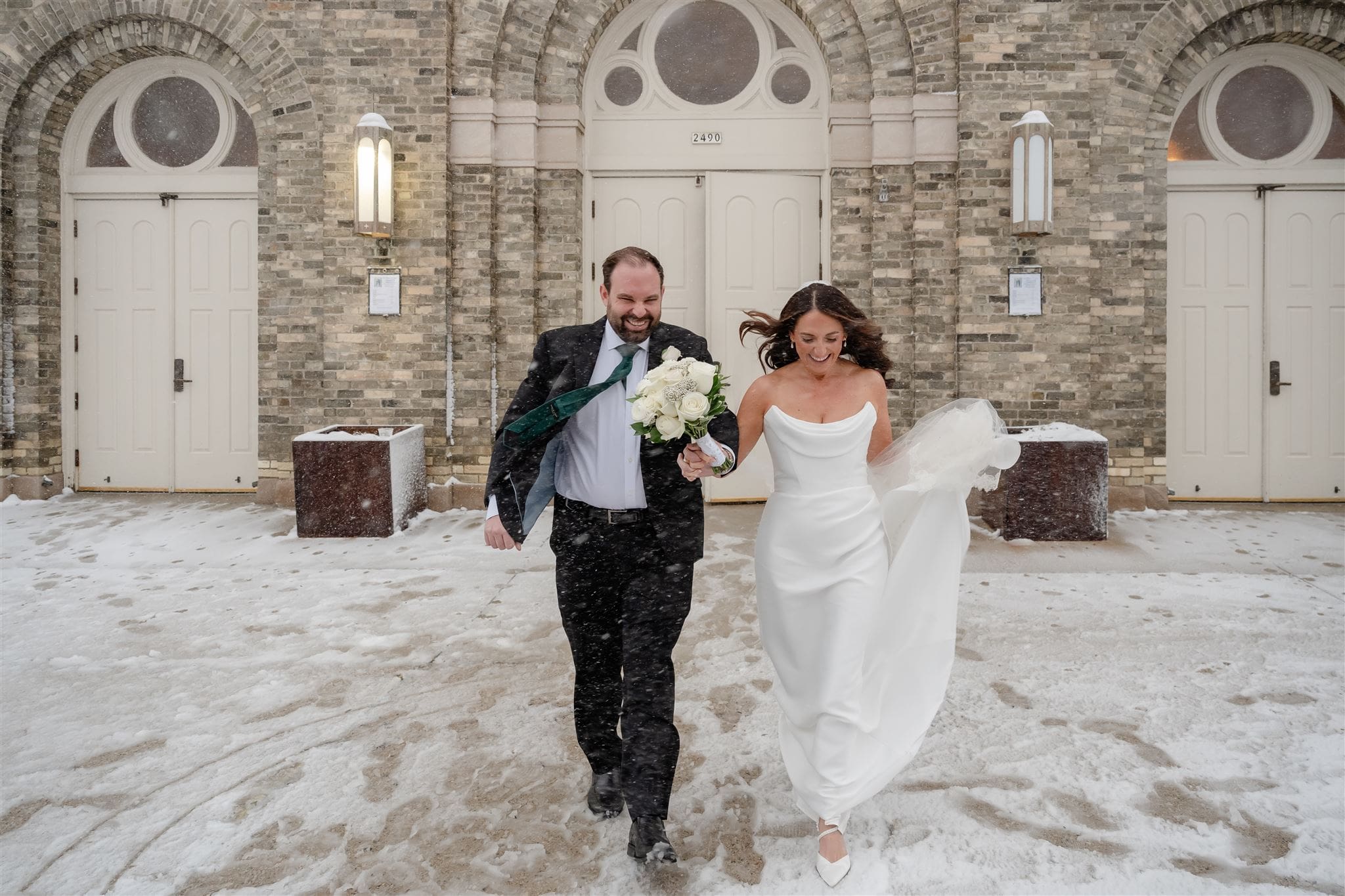 Bride and groom run out of church in a blizzard in Milwaukee.